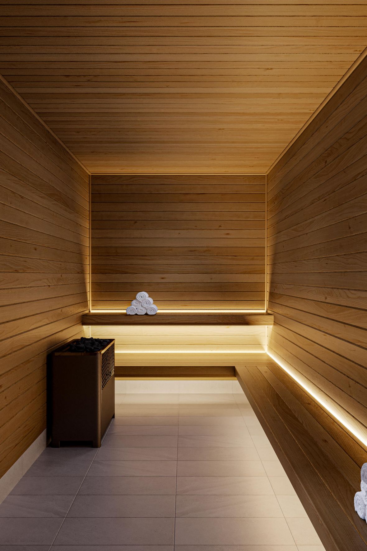 Modern wooden sauna with benches, stacked white towels, soft lighting, and a heater on the left side.