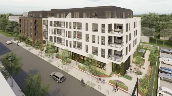 A modern, multi-story apartment building with balconies, street trees, and people walking on the sidewalk.
