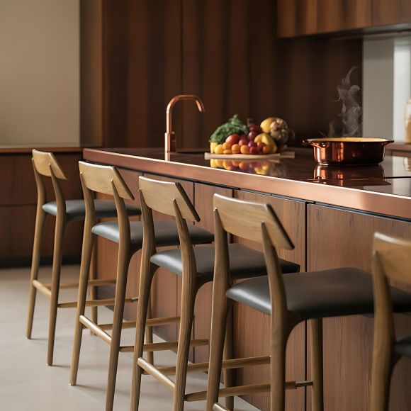 Modern kitchen with wooden bar stools, a copper sink, and fresh produce on the counter next to a steaming pot.